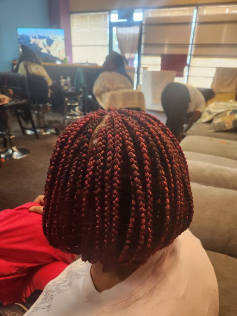 Red color hair braids of a woman